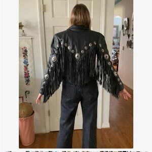 Genuine heavy leather black moto jacket with fringe and medallion detail.